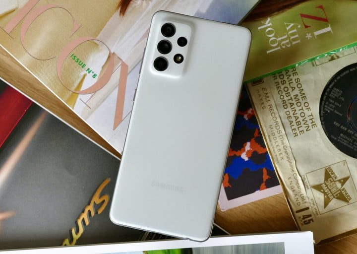 Celular visto por atrás sobre varias revistas para comparar al Galaxy A52 5G vs. Pixel 4a 5G