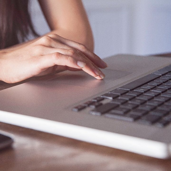 Una persona presiona el panel táctil o touchpad de su computadora.