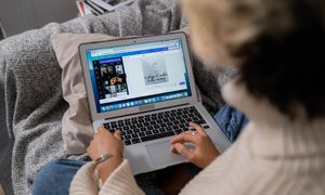 Una mujer diseña en Canva en una computadora