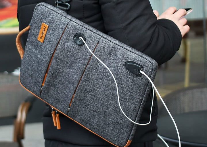 Un hombre con una Domiso Canvas Laptop Sleeve en la espalda