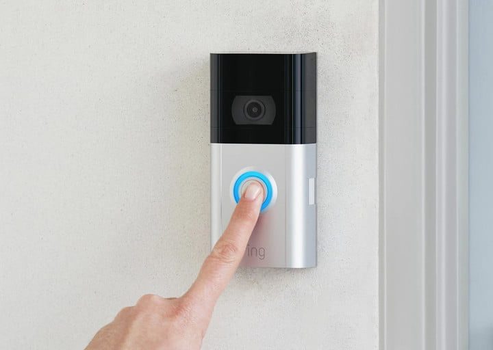 El dedo de una persona presionando el boton de un timbre montado en la pared, para comprar el Ring Video Doorbell 3 vs. Ring Video Doorbell Pro