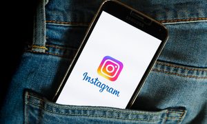 Un teléfono con el logo de Instagram sobresale del bolsillo de un pantalón.