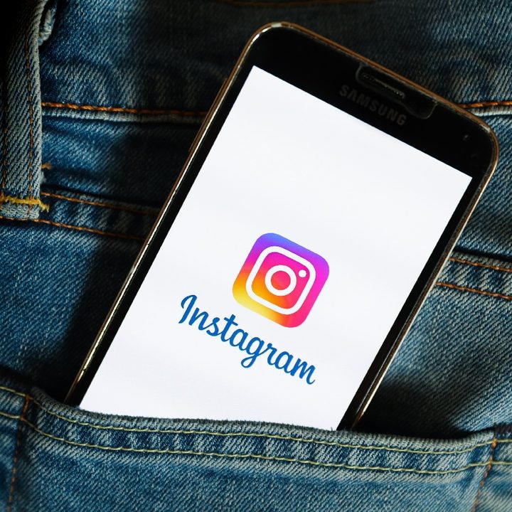 Un teléfono con el logo de Instagram sobresale del bolsillo de un pantalón.