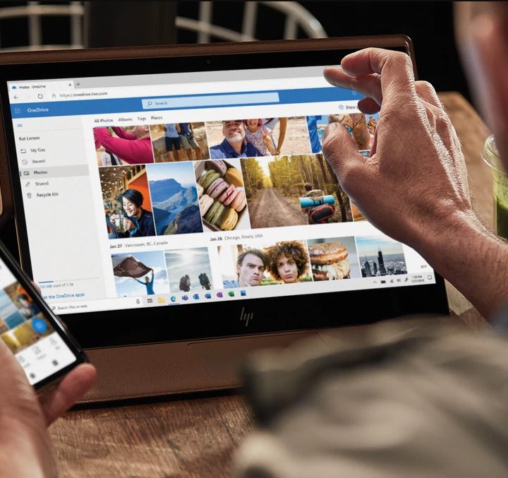 Un hombre usando su celular y su tableta para investigar qué es Microsoft OneDrive