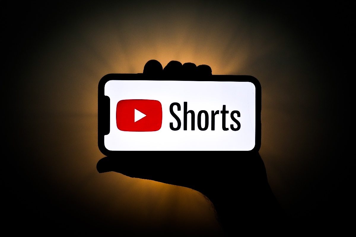 Una persona sostiene un tel&eacute;fono con el logo de YouTube Shorts