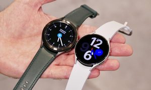 Una mano sostiene un reloj Galaxy Watch 4 Classic y un Galaxy Watch 4.