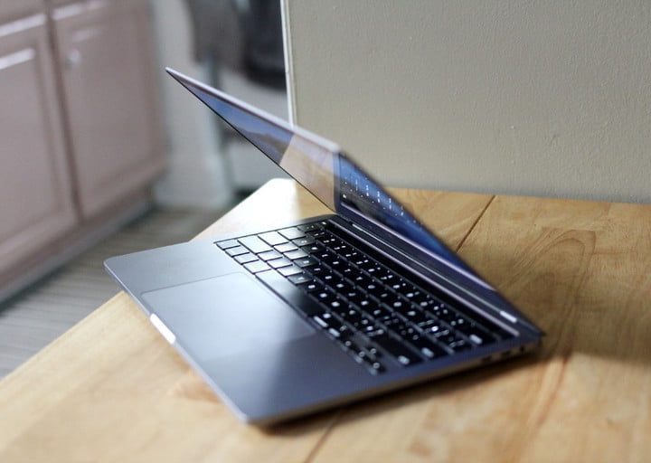 MacBook Pro 13 parcialmente plegada sobre una mesa de madera.