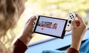 Una mujer instalando el controlador de Nintendo OLED para comparar Una mujer instalando el controlador de Nintendo OLED.