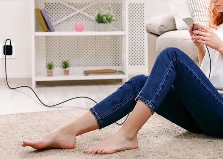 Una chica sentada sobre una alfombra usando su Syncwire USB-A to USB-C Charger Cord, uno de los mejores cables USB-C