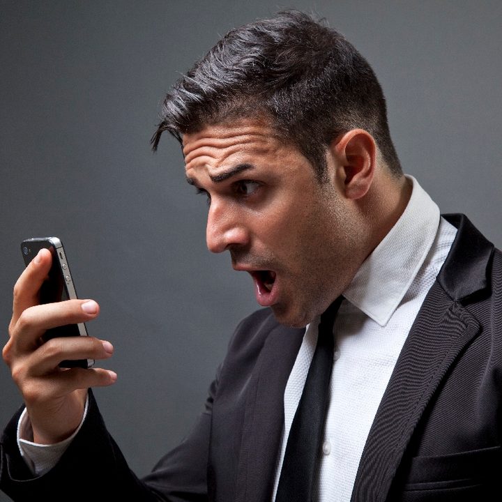 Un hombre mira con cara de sorpresa su teléfono