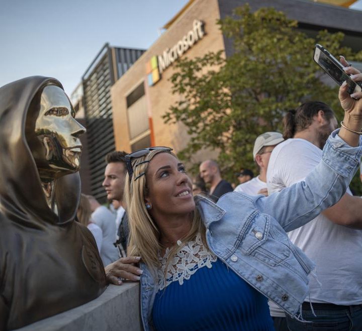 La imagen muestra una estatua levantada en homenaje al creador del bitcoin.