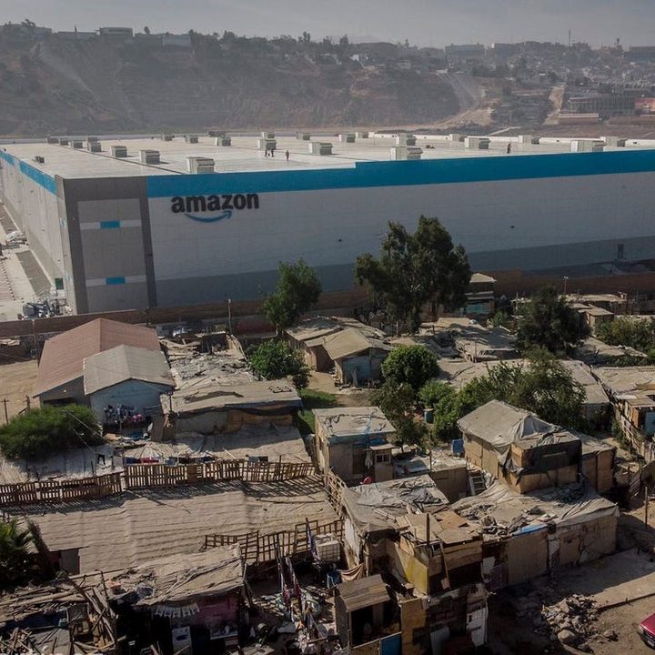 La imagen muestra un nuevo edificio de Amazon en medio de un sector pobre de Tijuana.