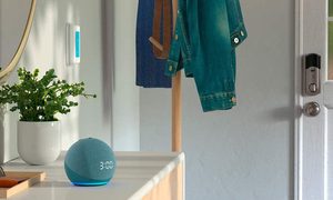 Amazon Echo Dot con reloj sobre una mesa, para aprender a agregar elementos a las listas de Alexa