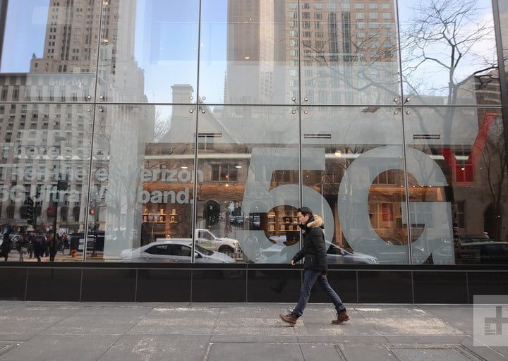 Una persona caminando fuera de una sucursal de Verizon para iniciar el proceso para desbloquear el celular.