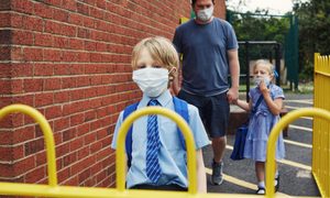 La imagen muestra a dos niños ingresando a una escuela en el Reino Unido.