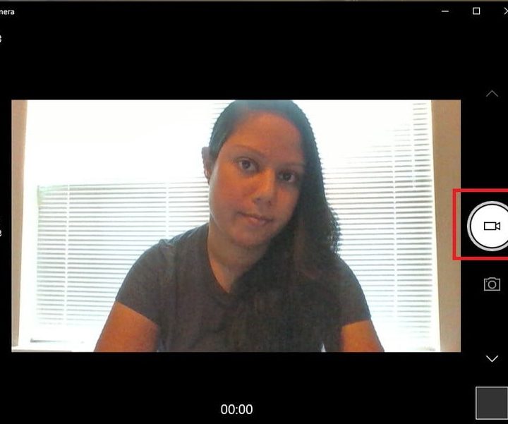 Una mujer graba un videoclip de sí misma en la aplicación Cámara de Windows 10 para probar la cámara web.