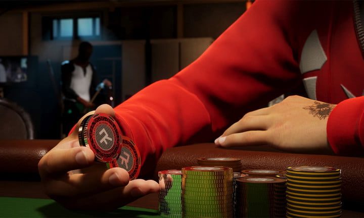 Un hombre con una sudadera con capucha roja sosteniendo fichas de póquer.