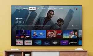 Televisor montado en una pared amarilla sobre consola de la sala para explicar qué es Android TV.