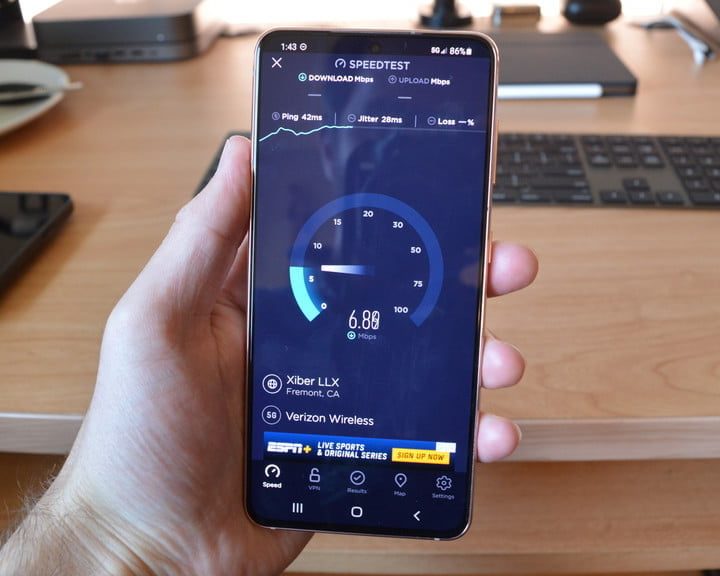 Una persona midiendo la velocidad de bajada de su acceso a internet con un celular para comparar 4G vs. LTE.