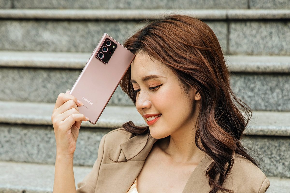 Una mujer apoya un teléfono Samsung Galaxy Note 20 ultra contra su frente.