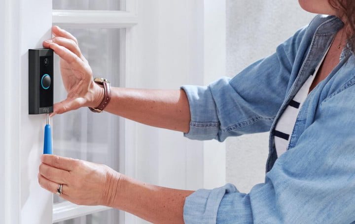 Una mujer cambiando la batería de un Ring Video Doorbell.