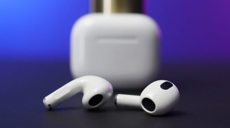 AirPods 3 con estuche de fondo para comparar AirPods vs. AirPods Pro.