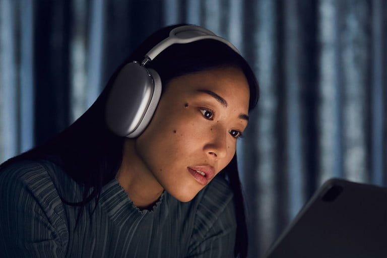 Una mujer usando Apple AirPods Max, para comparar los AirPods vs. AirPods Max.