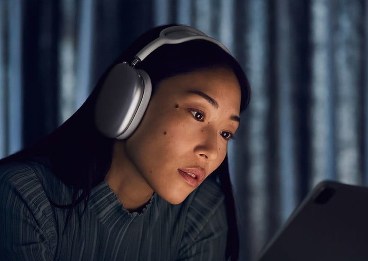 Una mujer usando Apple AirPods Max, para comparar los AirPods vs. AirPods Max.