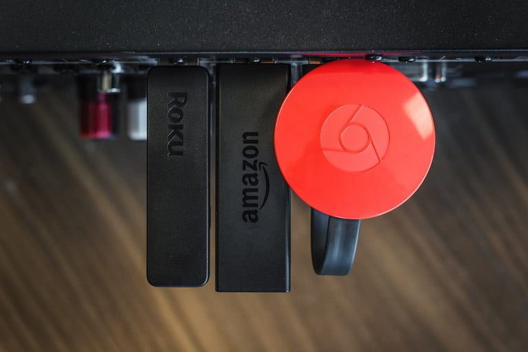 Dispositivos de streaming de Chromecast, Roku Stick, Amazon Fire Stick uno al lado del otro., para comparar los servicios de Hulu vs. Amazon Prime Video.