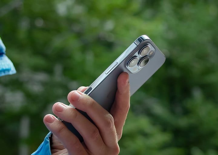 iPhone 13 Pro en la mano de una persona visto de lado.