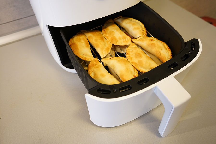 Freidora Mi Smart Air Fryer de color blanco con unas empanadillas fri&eacute;ndose dentro.