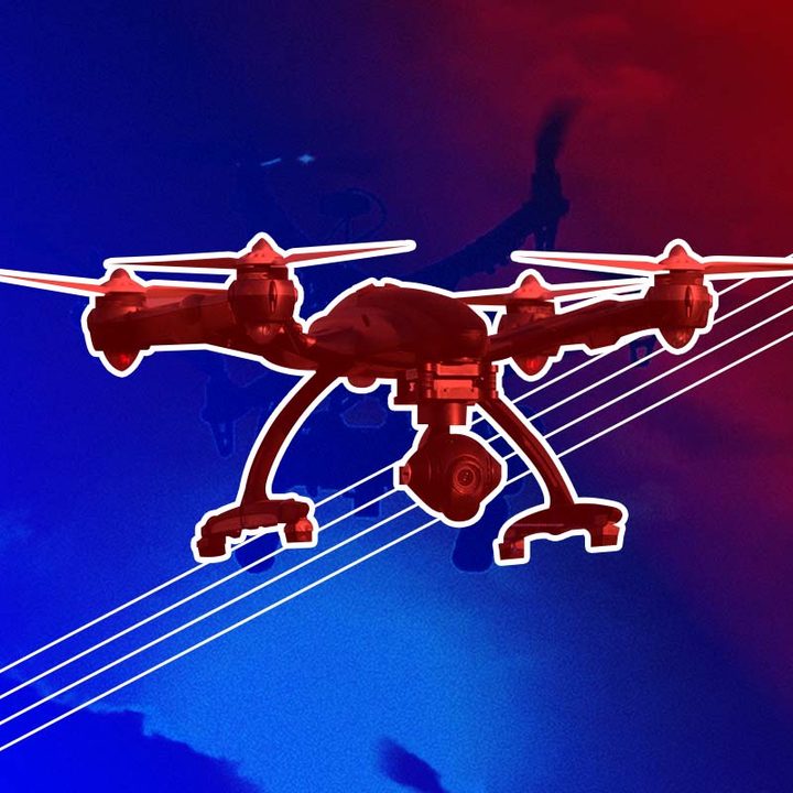 Un dron de cuatro hélices, una cámara y dos patas para soporte manteniéndose estable en el aire.