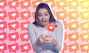 Una joven sosteniendo un teléfono inteligente con expresión de sorpresa, junto con un corazón que representa a los Me Gusta de Instagram saliendo de su dispositivo.