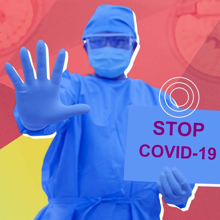 Un médico con un traje de protección con un cartel en la mano que dice: "Detengan al COVID-19".