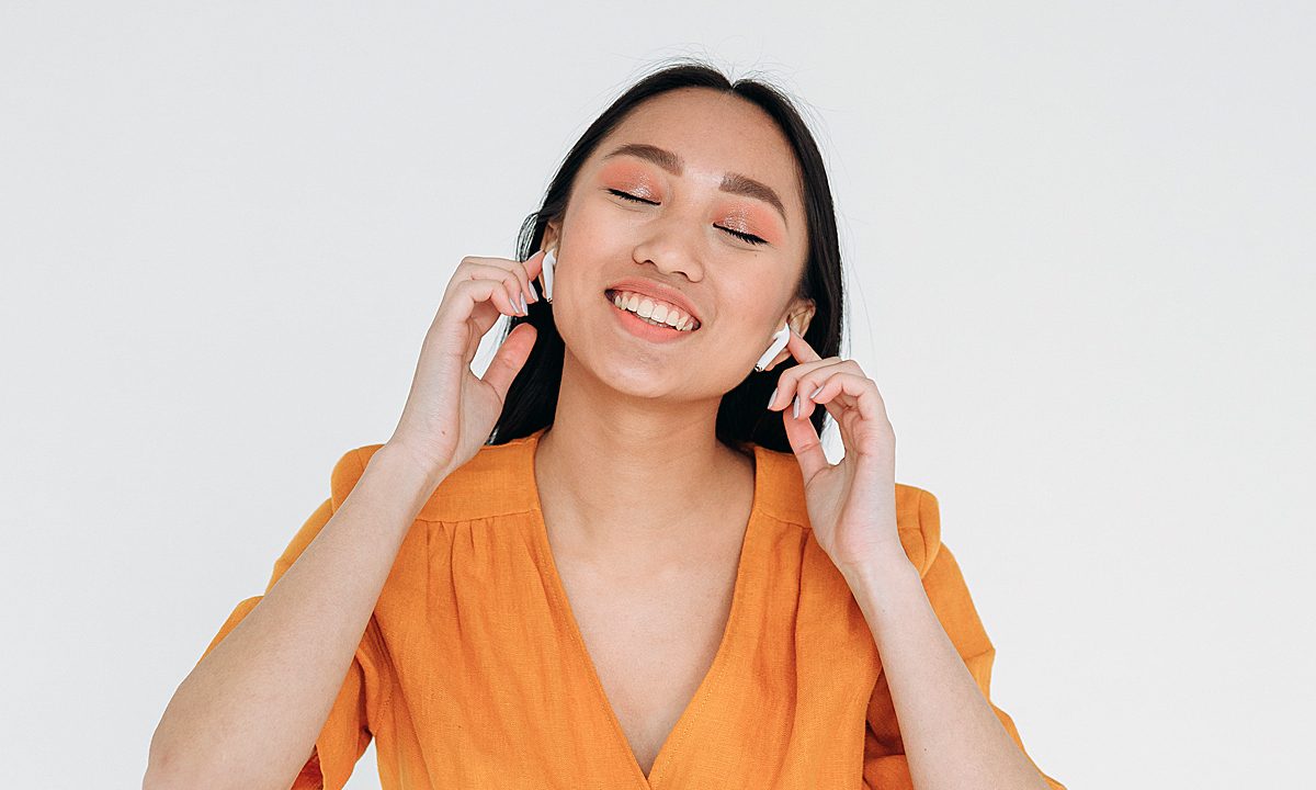Una mujer disfruta de la música que escucha con sus audífonos inalámbricos.