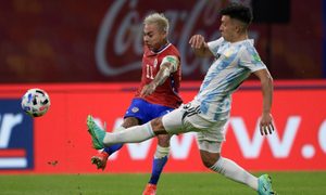 El atacante chileno Eduardo Vargas golpea el balón ante la presencia del defensa argentino Lisandro Martínez, en un partido por las eliminatorias a Qatar 2022.