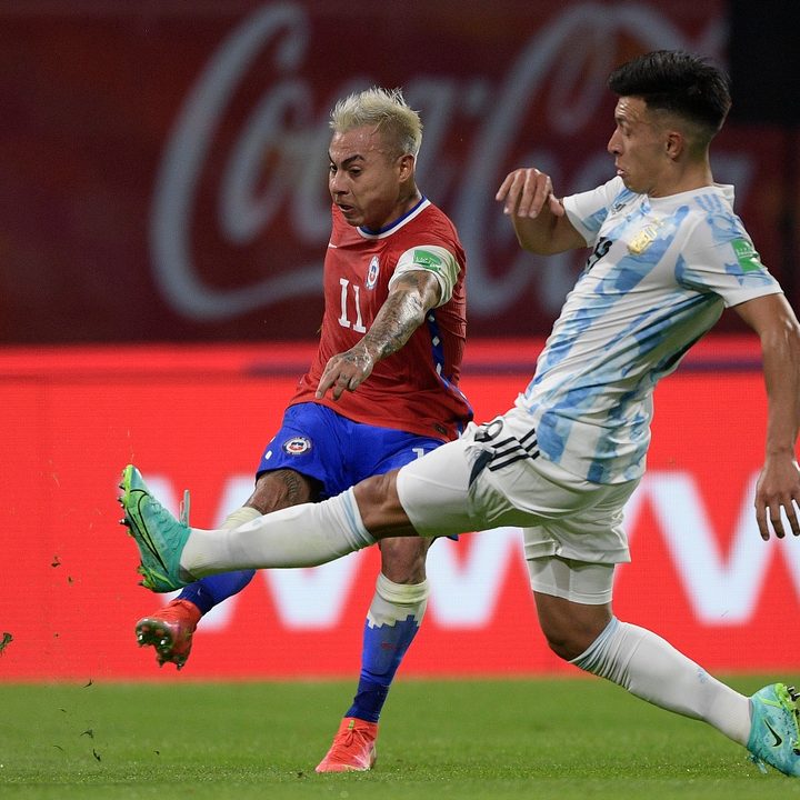 El atacante chileno Eduardo Vargas golpea el balón ante la presencia del defensa argentino Lisandro Martínez, en un partido por las eliminatorias a Qatar 2022.
