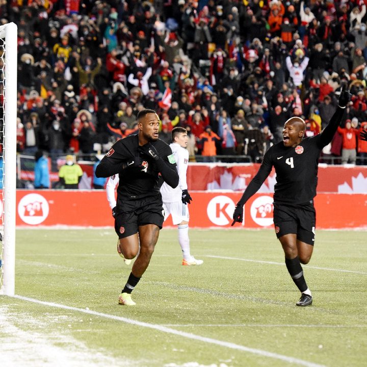 Cyle Larin corre a través del campo de juego para celebrar un gol de Canadá