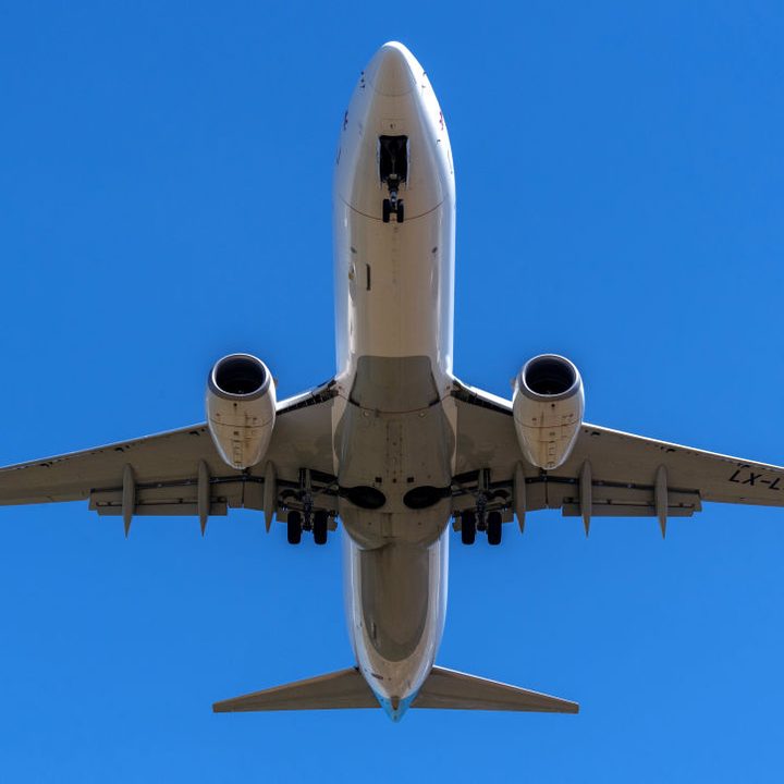 La imagen muestra la parte inferior de un avión mientras despega.