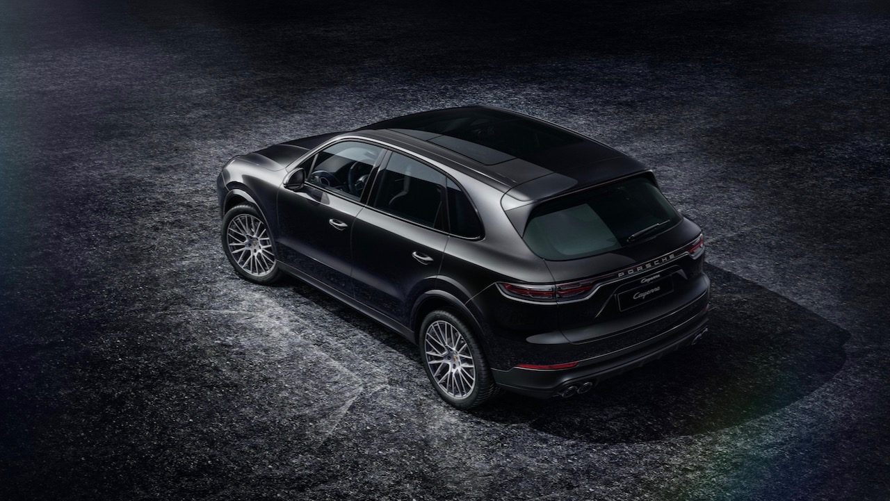 Vista trasera superior de dos cuartos de la Porsche Cayenne Platinum Edition 2022 en estacionada en un estudio con fondo negro.