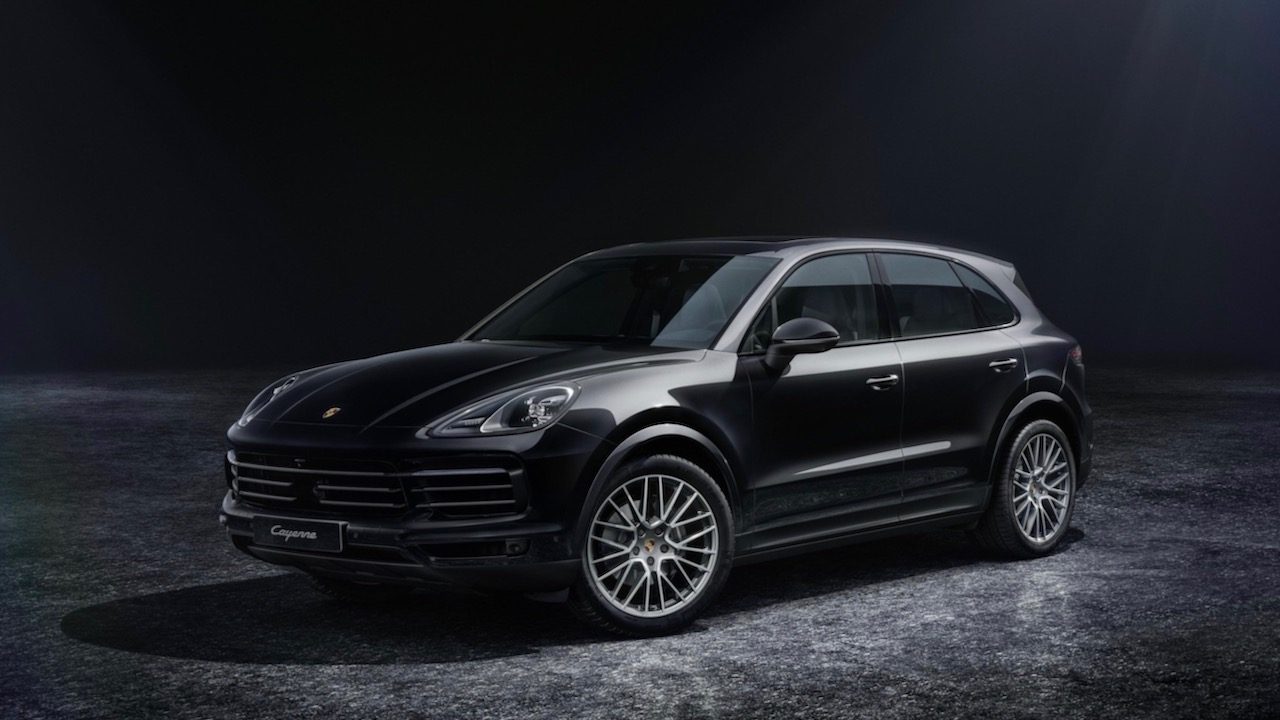 Vista frota de dos cuartos de la Porsche Cayenne Platinum Edition 2022 en estacionada en un estudio con fondo negro.