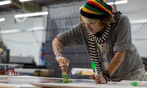 La imagen muestra al actor Johnny Depp pintando un cuadro.