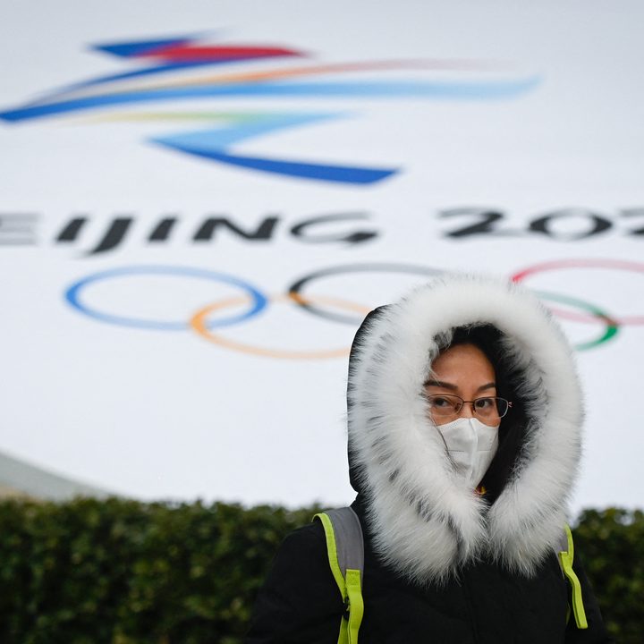 Una mujer camina frente a una instalación que promueve los Juegos Olímpicos y Paralímpicos de Invierno de Beijing 2022.