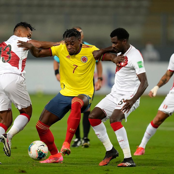 El colombiano Duván Zapata disputa el balón ante los peruanos Renato Tapia y Christian Ramos en un partido de fútbol disputado en Lima.