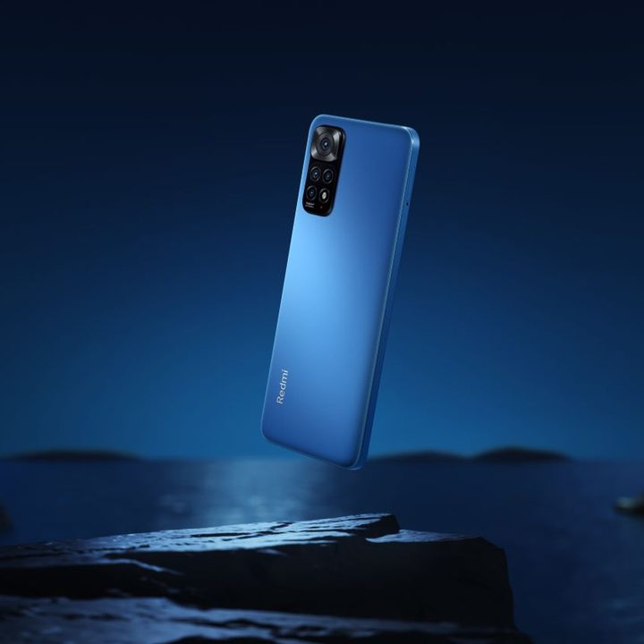 Redmi Note 11 S volando en el aire con un fondo oscuro