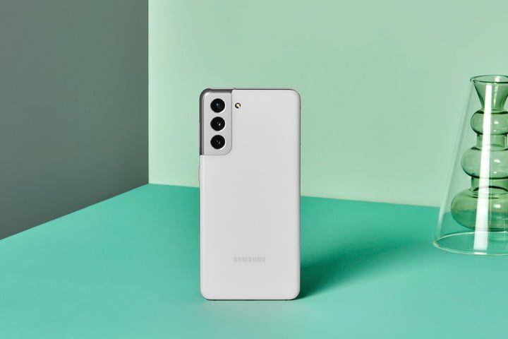 Samsung Galaxy S21 en posici&oacute;n vertical sobre una superficie verde mostrando su m&oacute;dulo de c&aacute;mara triple.