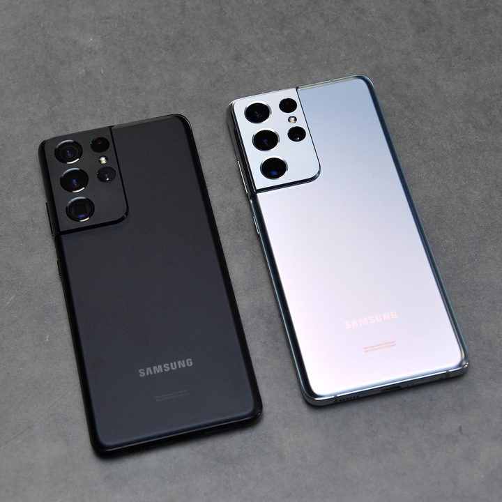 Dos modelos Samsung Galaxy S21 sobre una mesa de mesa gris.