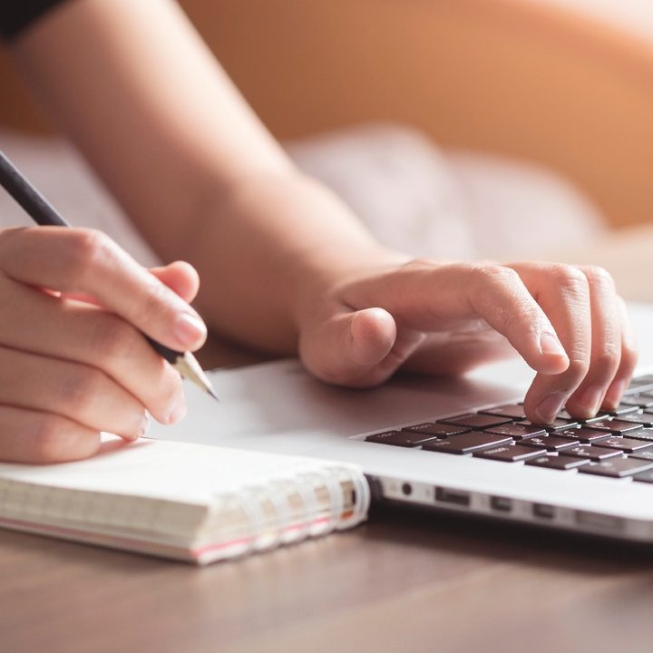 Una persona toma apuntes en una computadora