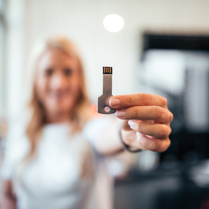 Mujer sostiene una llave USB