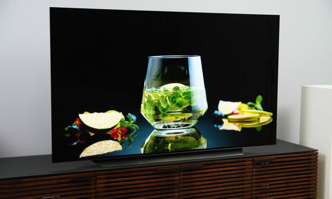 Televisor LG CX OLED TV sobre una consola para comparar QD-OLED vs. QLED